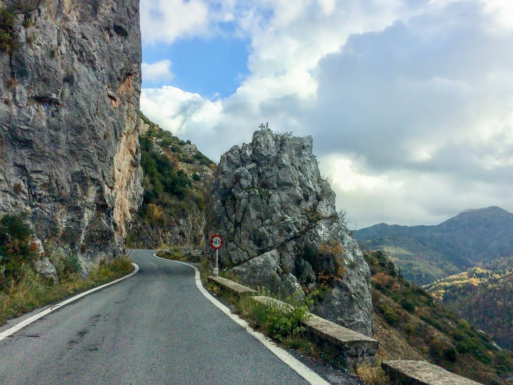 Narrow greece road with rocks either side