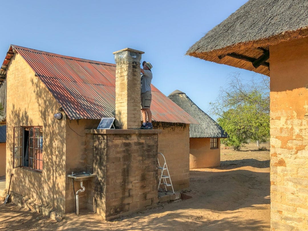 Lars working-on-a-rondavel-chimney to make sure all bats were out and couldn't get back in again. 