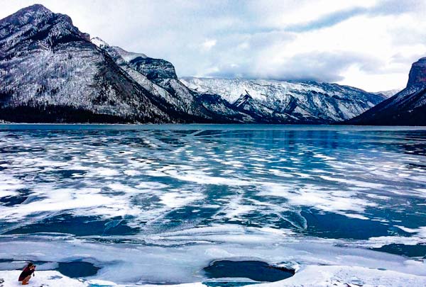 Lake-Minnewanka-banff-National-Park - blue water with ice on top and mountains in the background