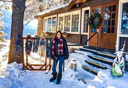 Log-cabin-and-snow-shoes and Shelley beside them