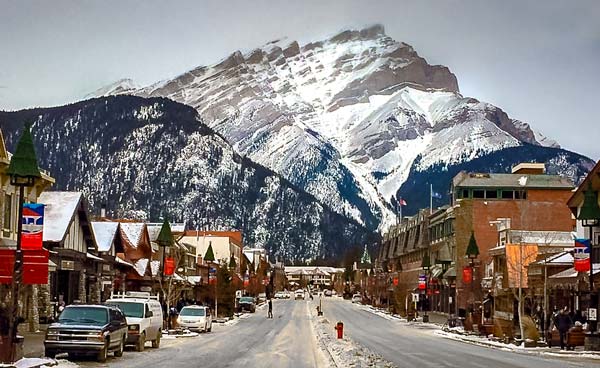 banff-Town-at-Christmas - main street with shops and houses either side and a huge mountain in the background