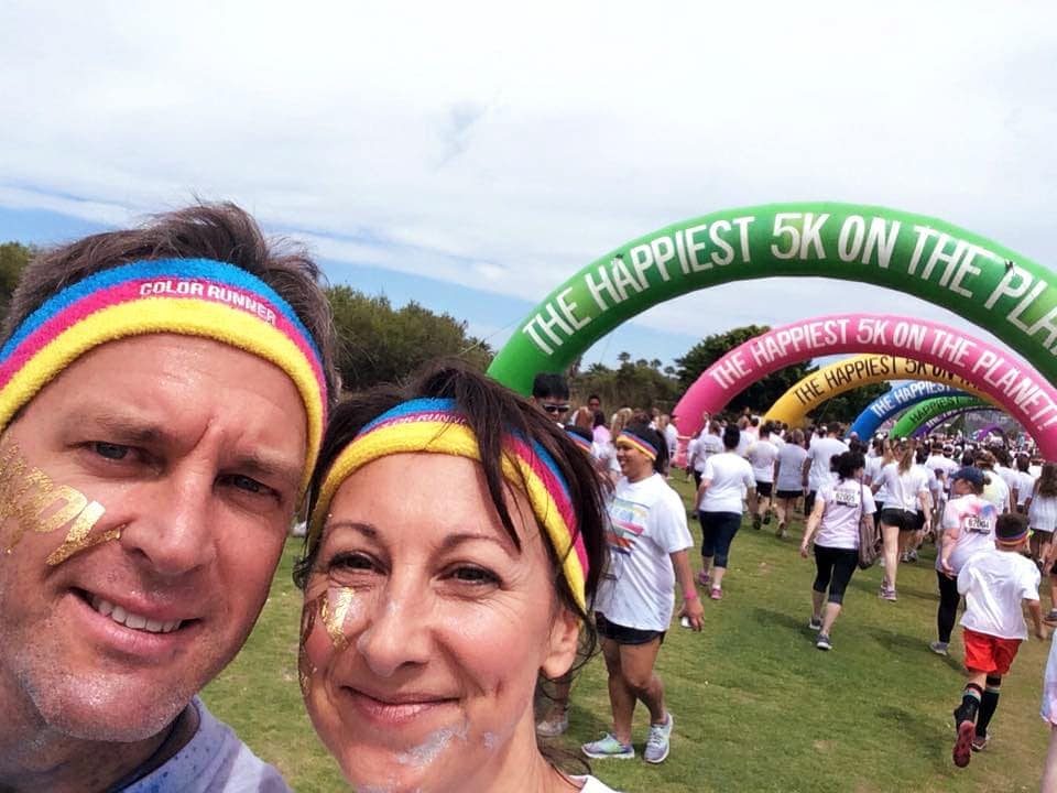 two people smiling at the happiest 5 km colour run with coloured headbands as an example of the importance of smiling