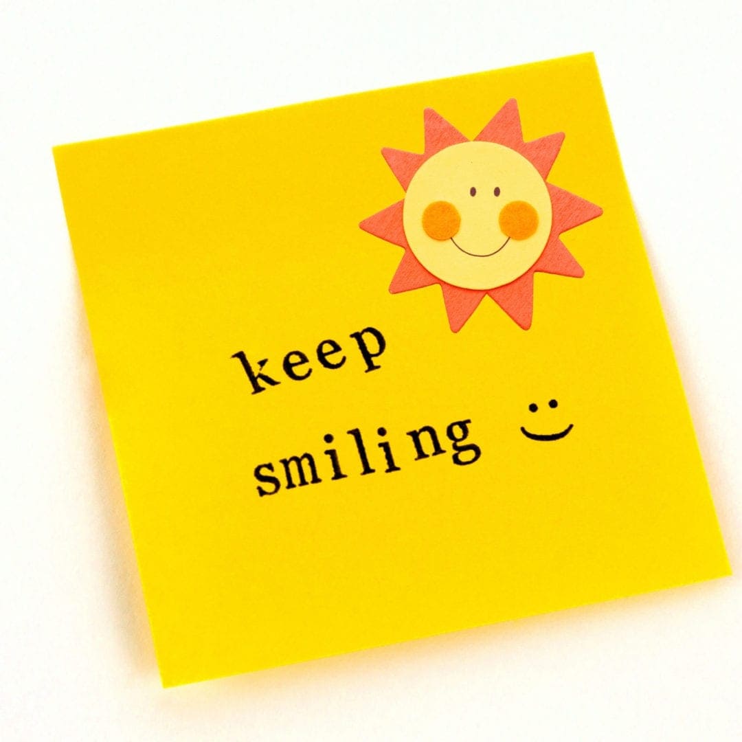 keep smiling written on a yellow post it note 