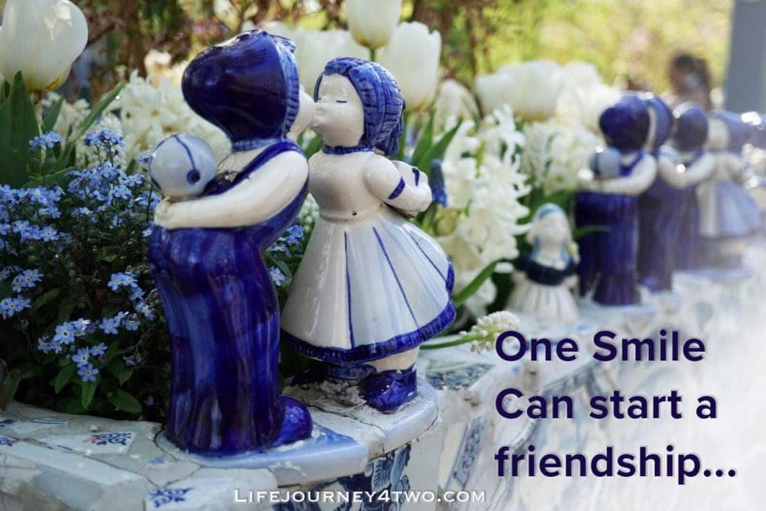 blue and white pottery figurines kissing with quote - one smile can start a friendship