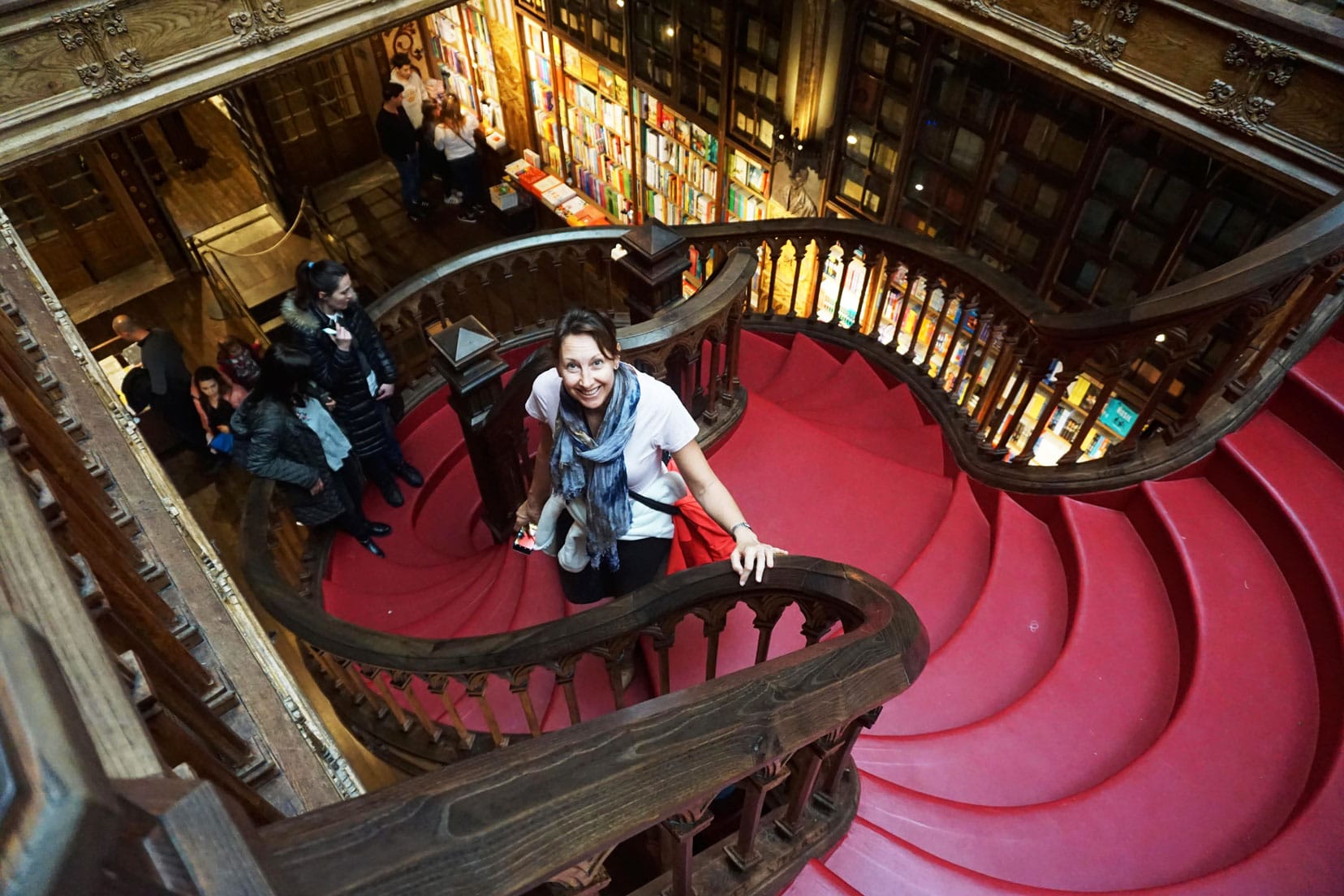 Shelley in the Livraria Lello in Porto on the red spiral staircase surrounded by floor to ceiling bookshelves