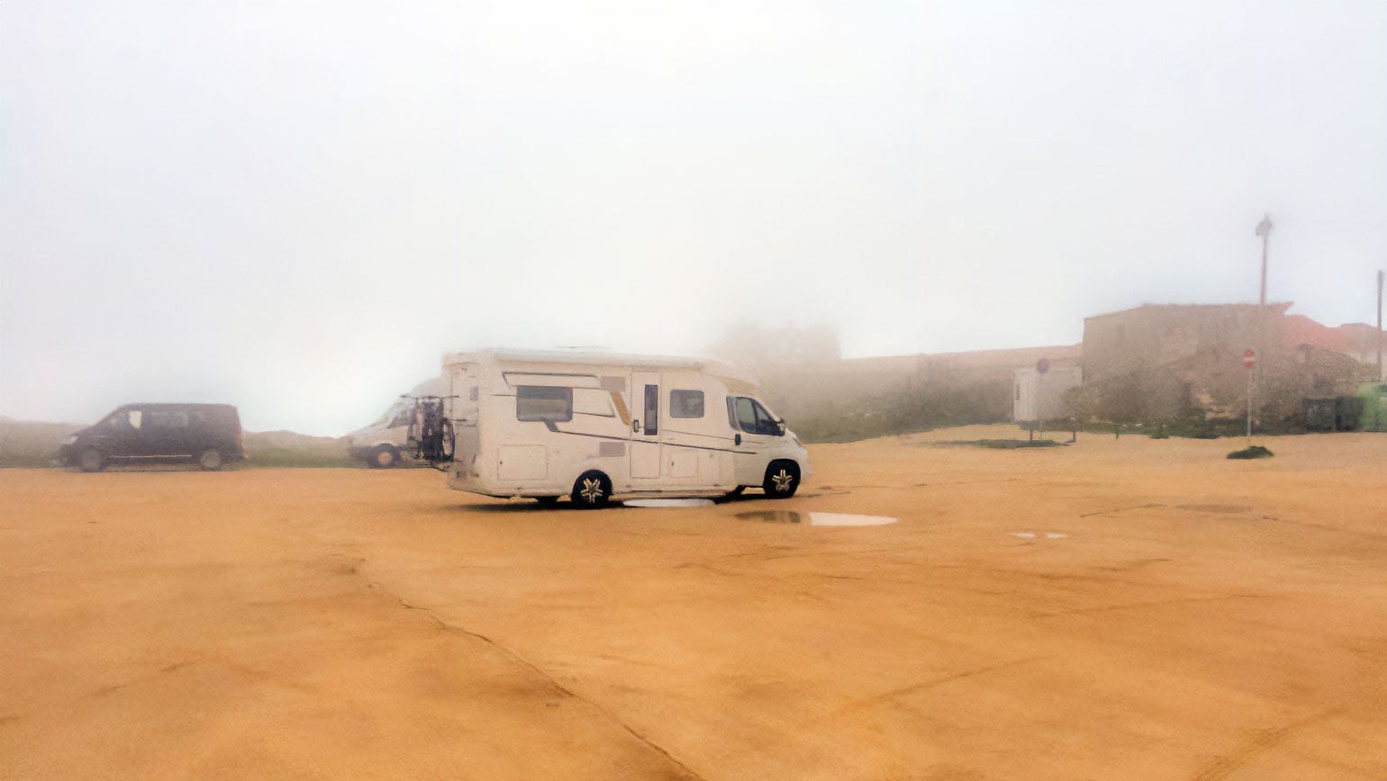 our motorhome parked in the carpark of Cabo Espichel which is sandy and engulfed in fog 