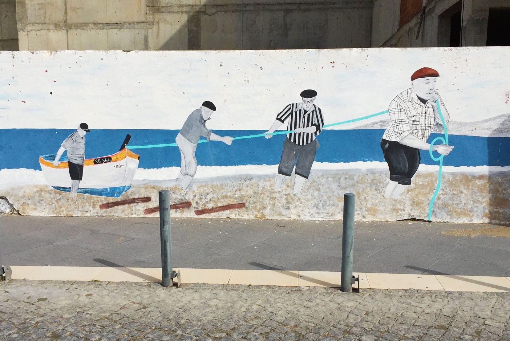Sesimbra street art with fisherman pulling a boat out of the water