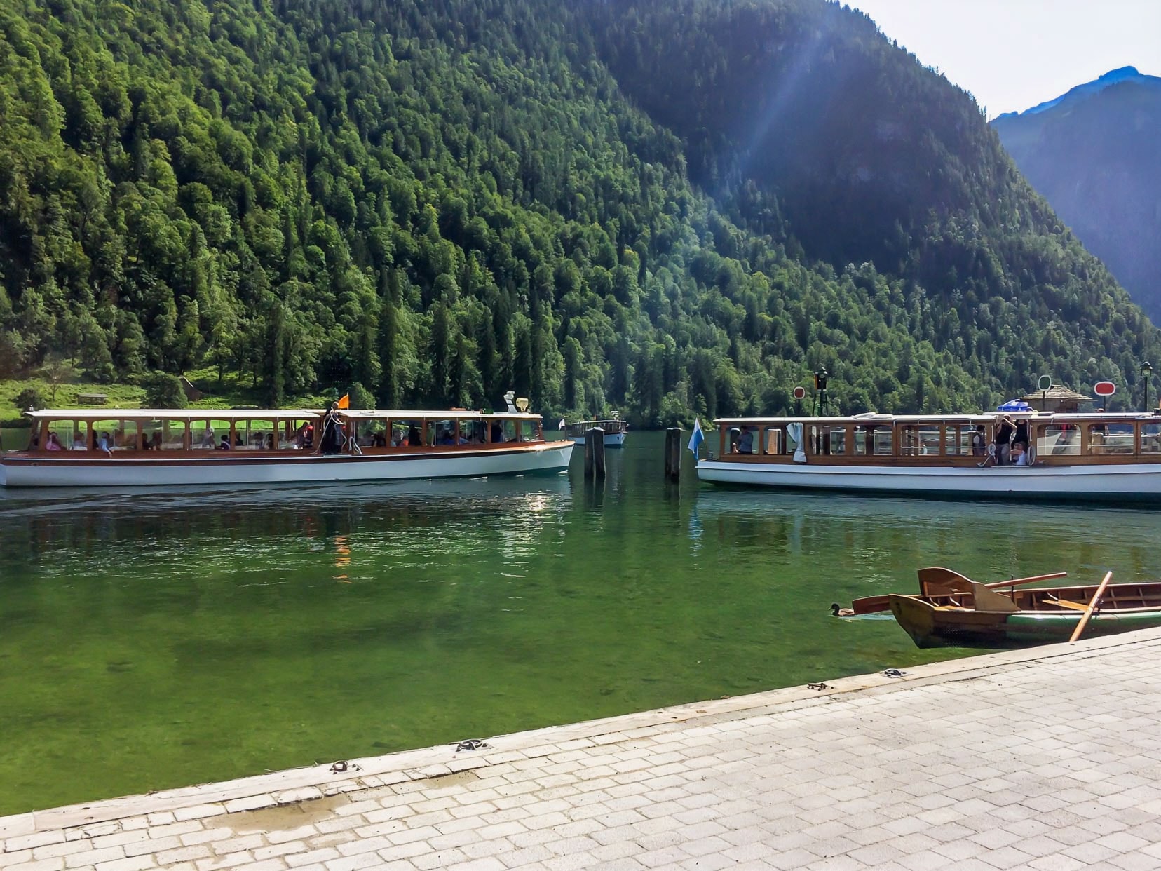 Lake-konigssee-electric-boats with green treed mountains behind 