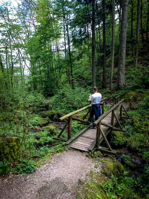 lars stood on wooden bridge acrossthe river on the Alde Gott Trail, Sasbachwalden