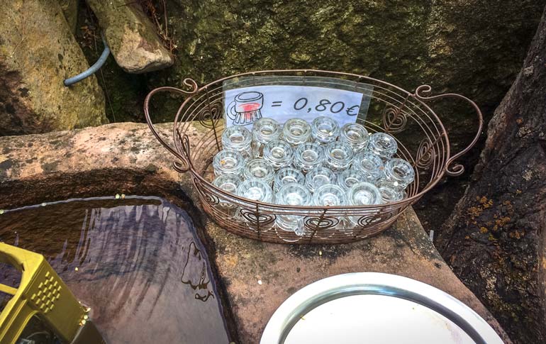 tray of glasses beside a fountain trough