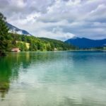 Walchensee, Germany - a lake with pin trees and small buildings on the edge