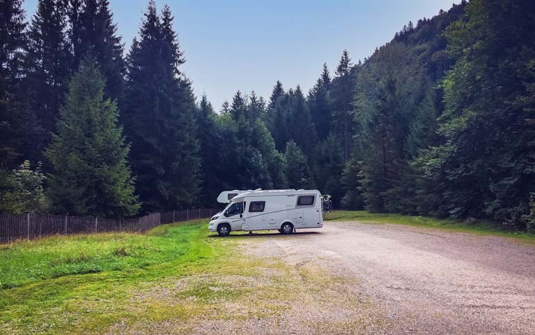 Walchensee-campsite, motorhome parked in a large carpark surrounded by  pine trees