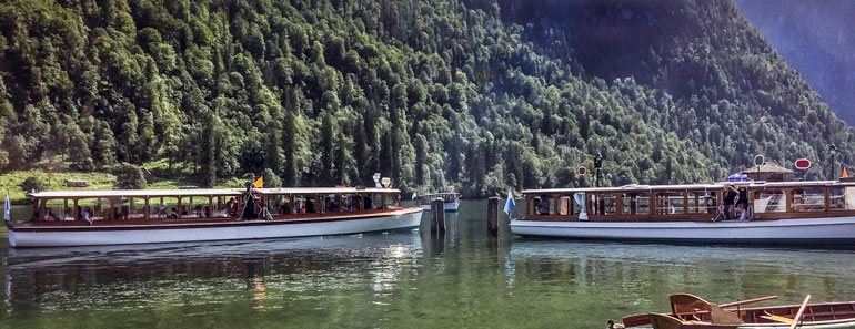 Two konigssee electric boatswith a backdrop of the mountains over lake Konigssee