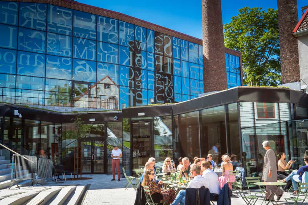 print museum with letters on its windows and a cafe with outside diners