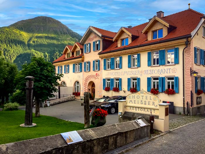 Decorative hotel facade and backdrop of mountains in Guarda Switzerland