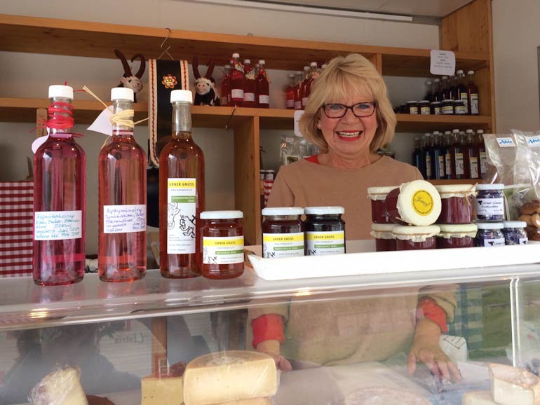 local stood behind her cheeses, honey and wines at Oberalp pass  car park