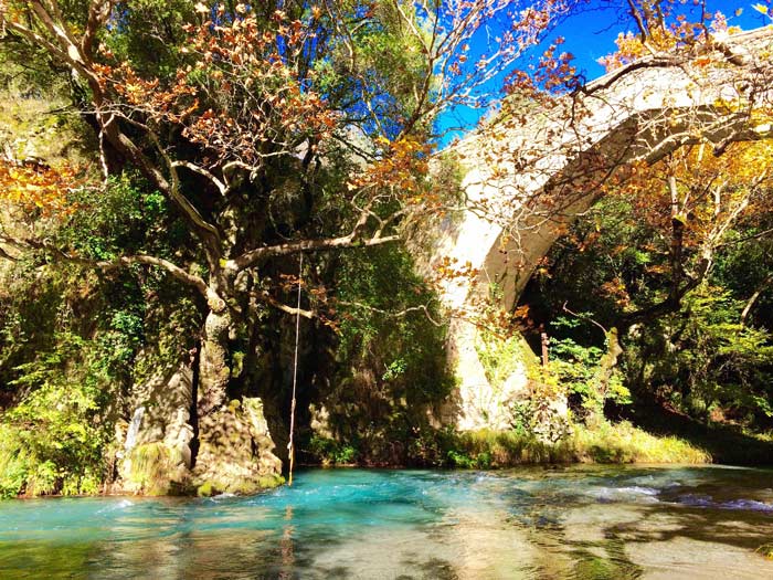 Lousios River with old stone bridge and autumn trees