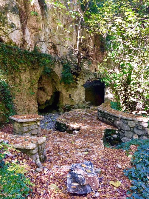Prodromou fulling tub at Lousios Gorge old stone arches curve into wall with lots of fallen autumn leaves around