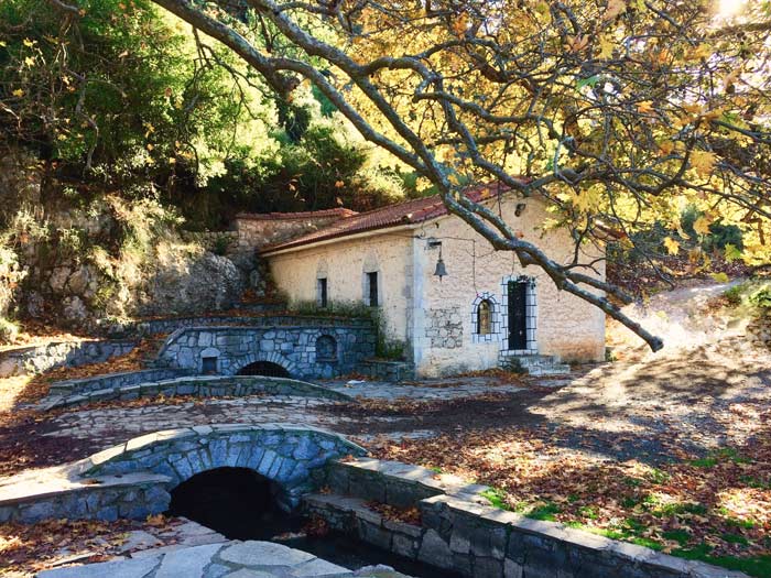 St Ioannis chruch with two old stone bridges beside it and an autumn tree