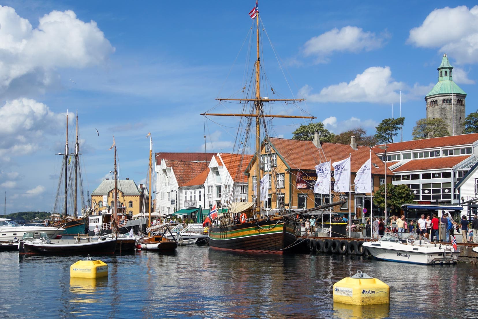 Harbourside at Stanavger with a tall ship and white timber buildings 