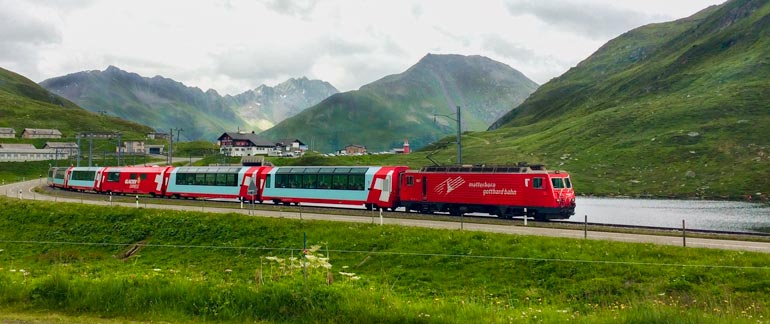 red train surrounded by alpine mountains in Switzerlands