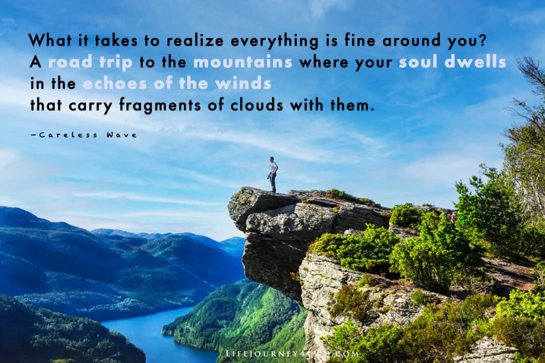 road trip quote on a photo of a man stood on a high precipice of rock over a winding fjord below