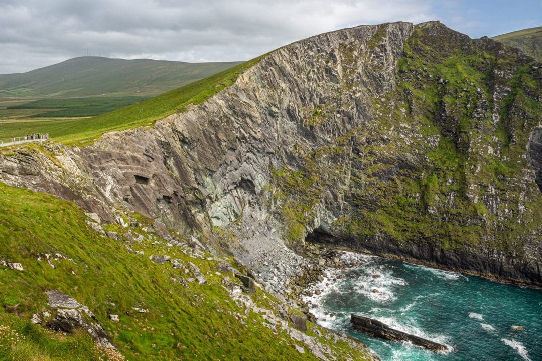 Rocky steep cliffs that fall steeply into the ocean with a grassy surface on top