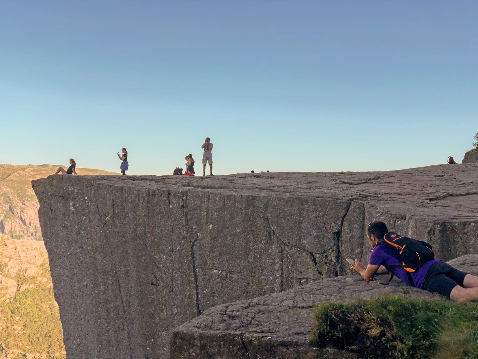 People having photos from the rock plateau after hiking Pulpit rock