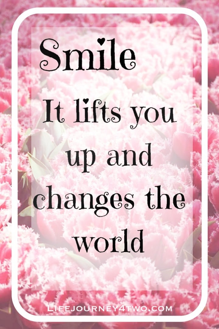 smile it lifts you up and changes the world  quote on pink carnation background