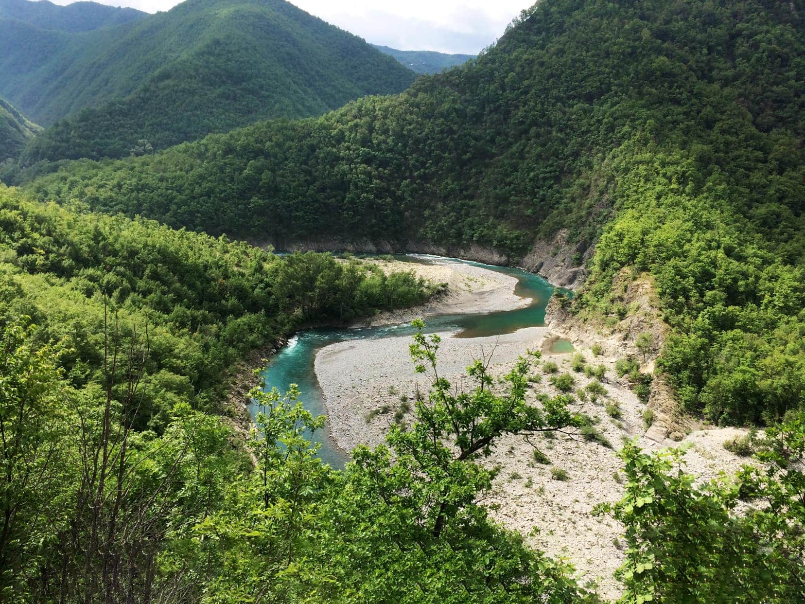 turquoise windy river in amongst high verdant green mountains