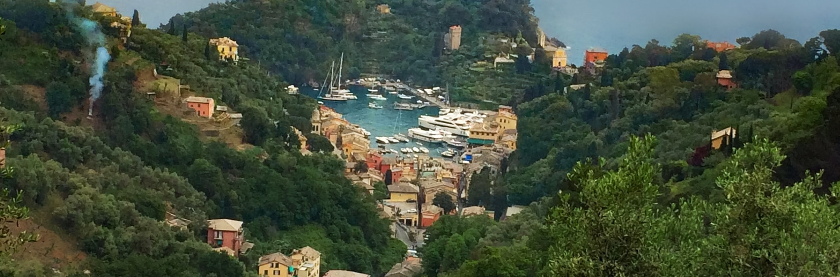 View of portofno from hills above - small harbour looks like a circle filled with boats. 