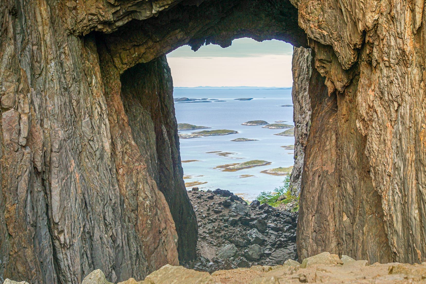 hole-in-a-mountain-looking-at-sea-with-many-small-islands