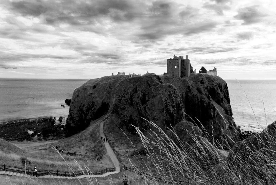 Dunottar castle ruins on a separate piece of rocky land connected by a small section to the main land