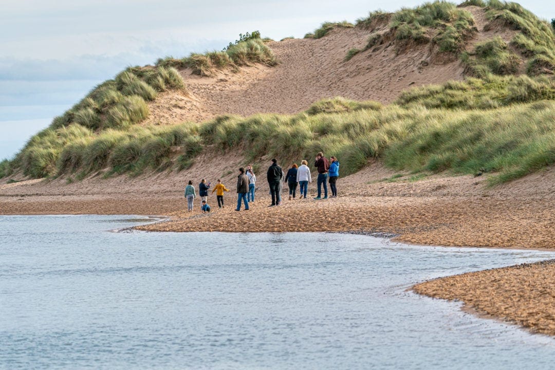 newburgh beach sand dunes with a family walking along the beach