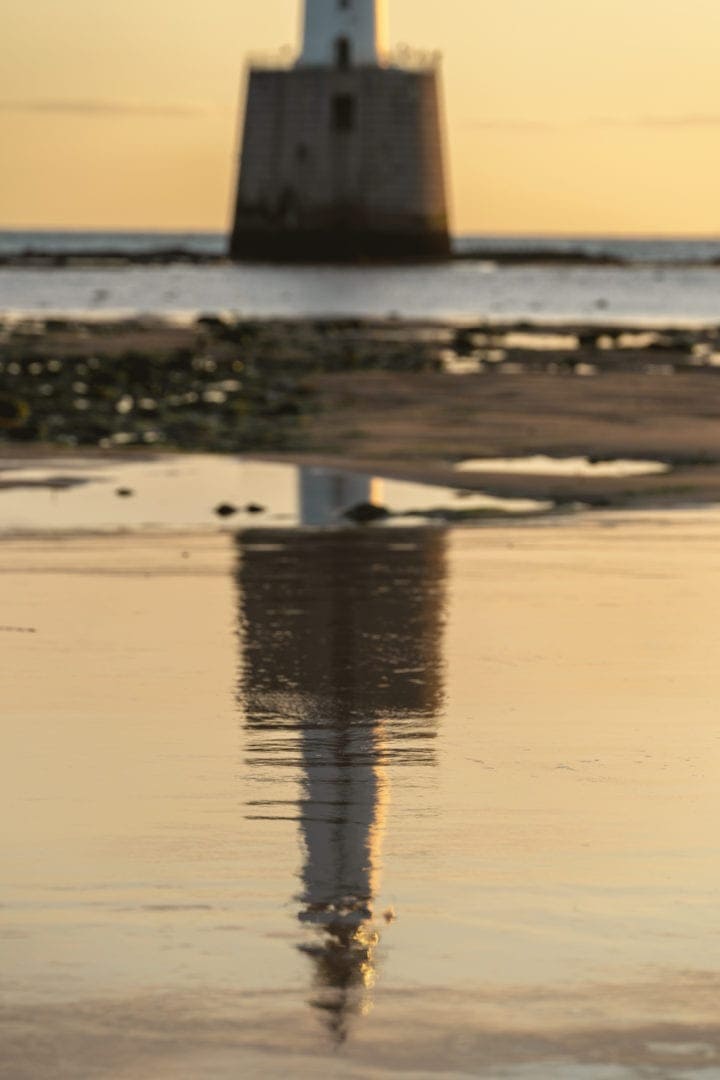 Rattray lighthouse with a vivid reflection in the wet sand 