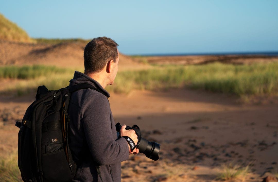 Lars with camera looking towards Rattray Head beach