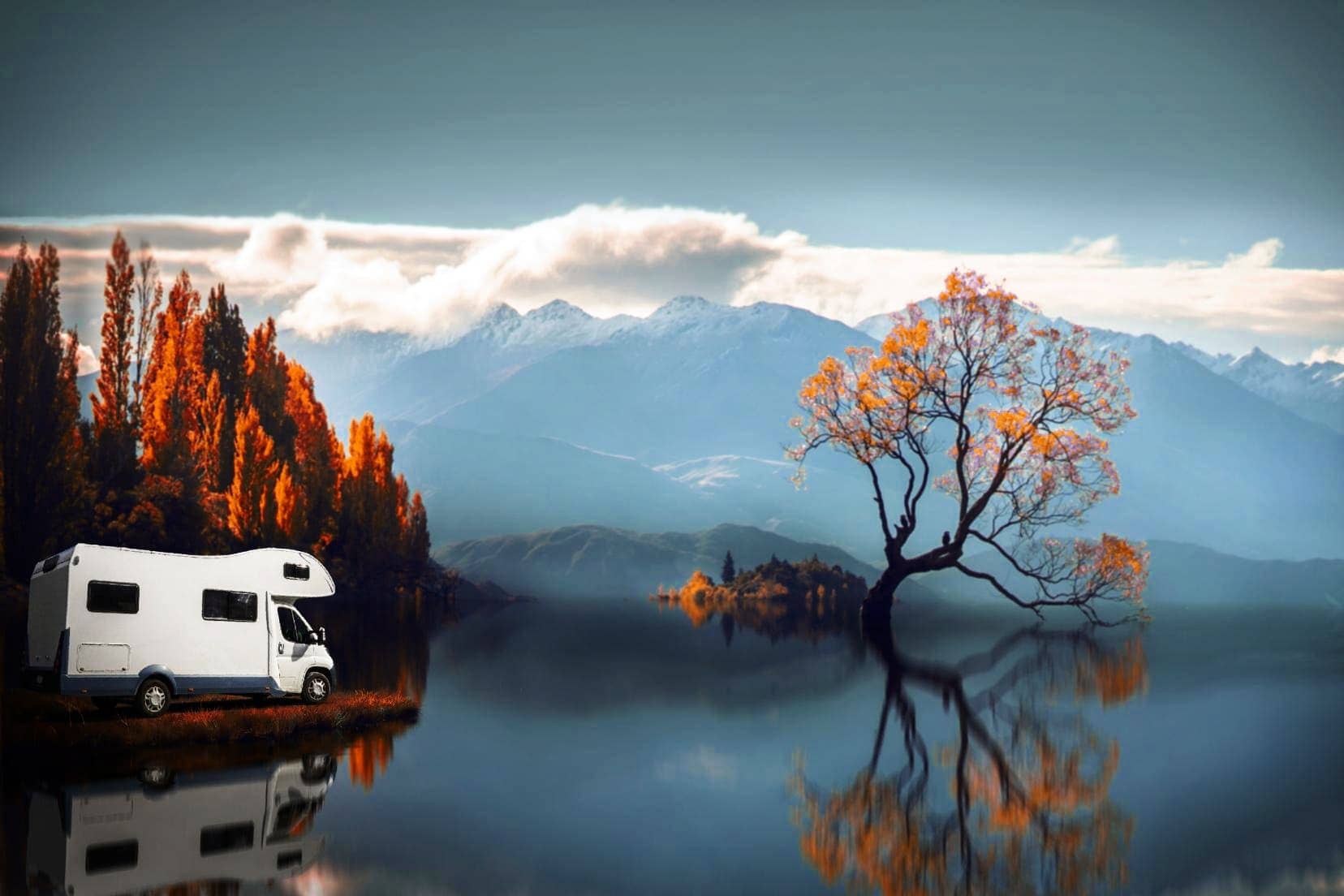 motorhome by a lake with red trees