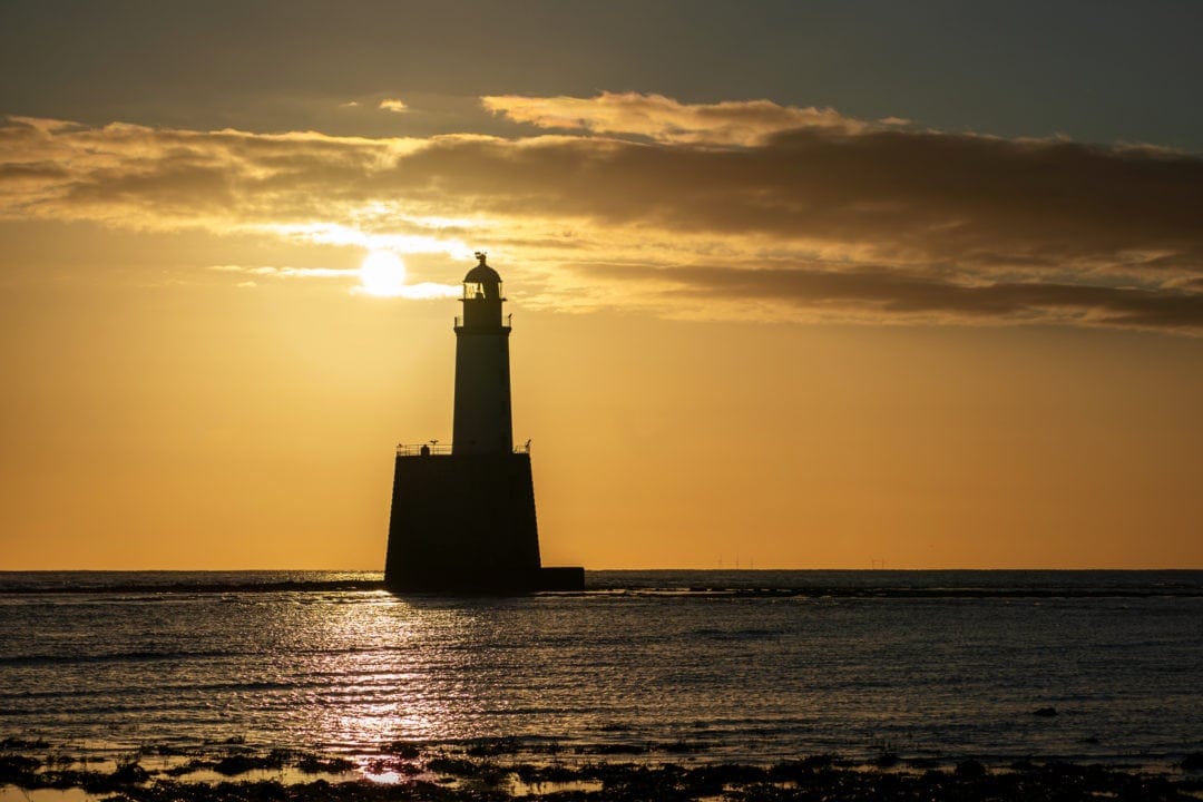 Rattray Lighthouse with sun rising behind the lighthouse