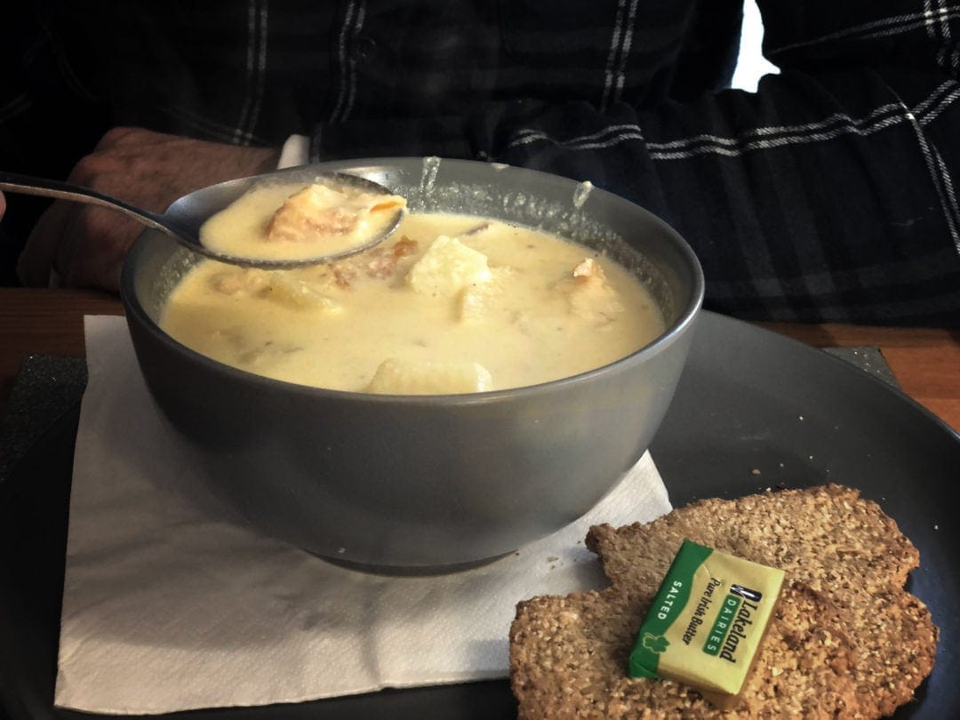 cullen skink soup - yellowy broth with lumps of smoked salmon and potatoes with a side of oat cakes and butter