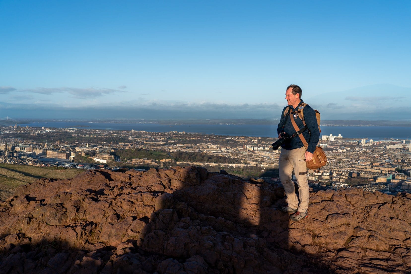 Lars stood on the brown rocky  summit of Arthurs seat