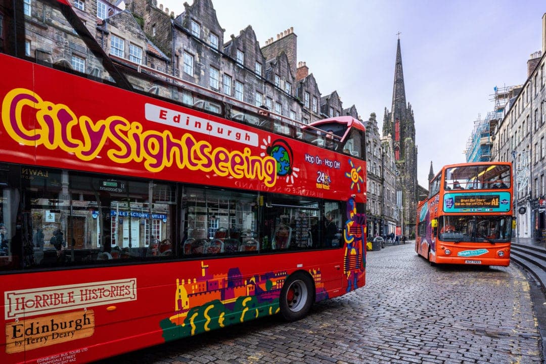Red double decker hop on hop off bus x 2 on the Royal Mile  in Edinburgh