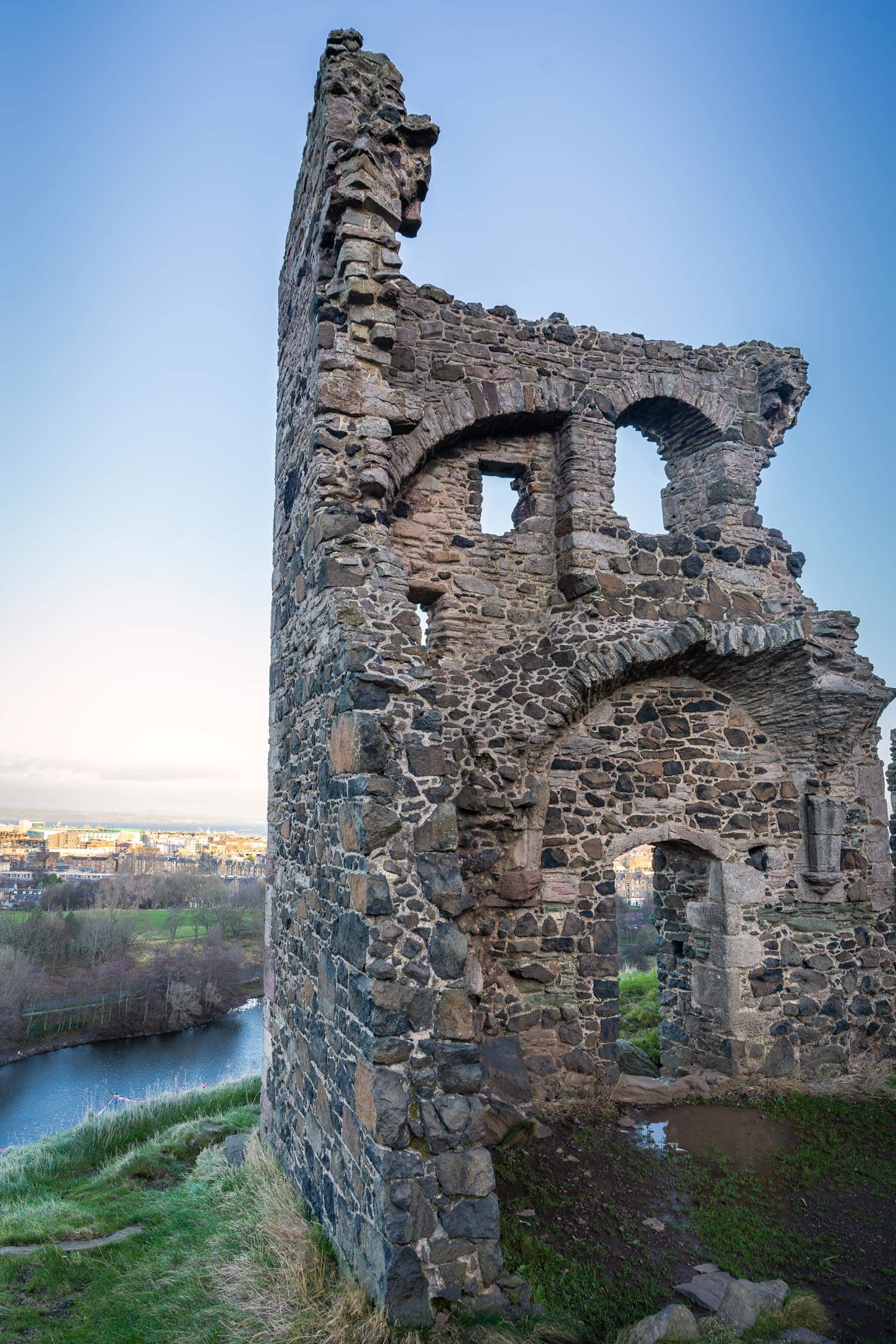 Ruined wall of St Anthony's Chapel with view of St Margaret's Loch below