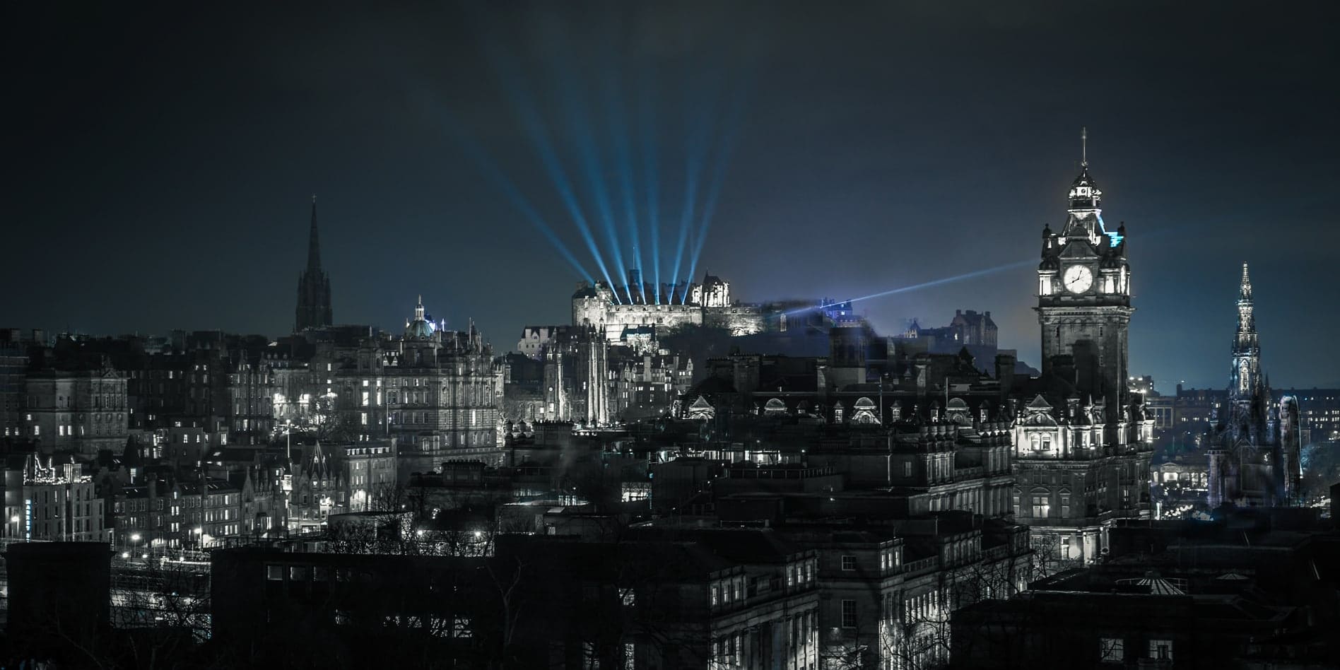 Walking-in-Edinburgh-Header-Photo night scene of edinburgh with blue laser beams coming from the top of Edinburgh castle