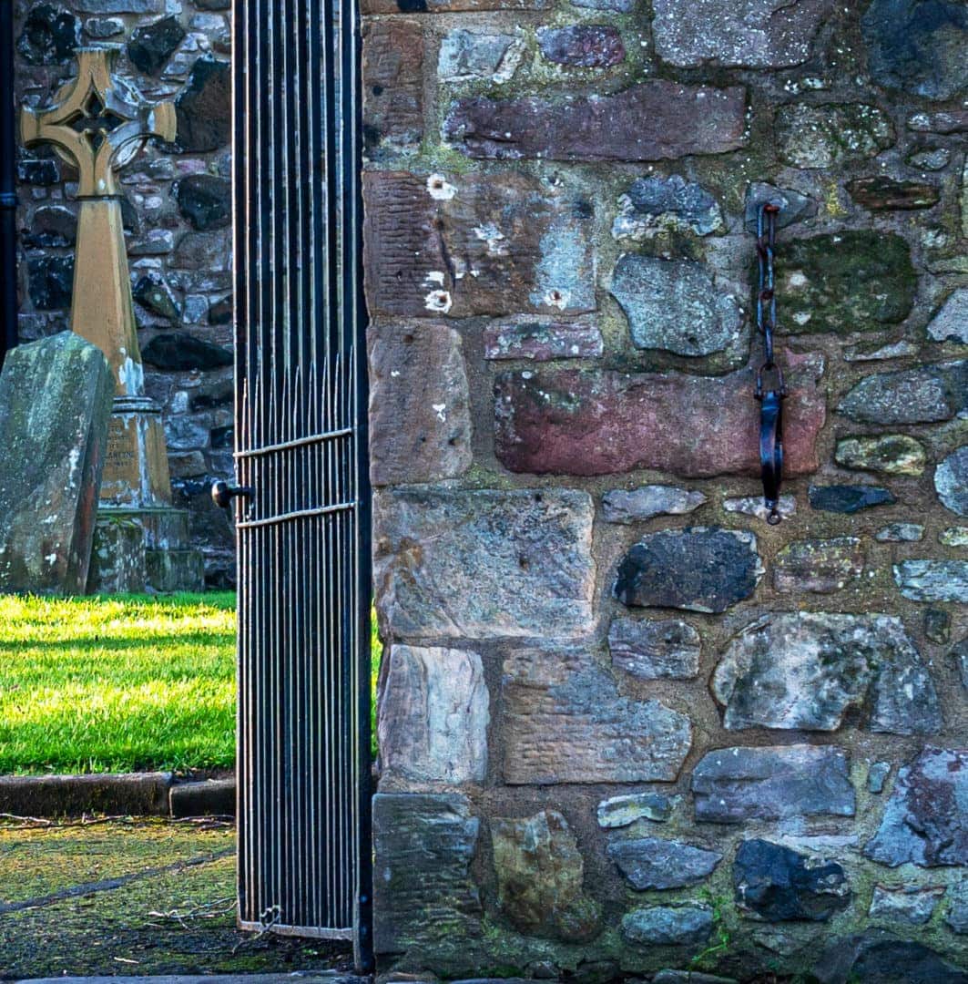 An iron chain and collar attache to the church wall 