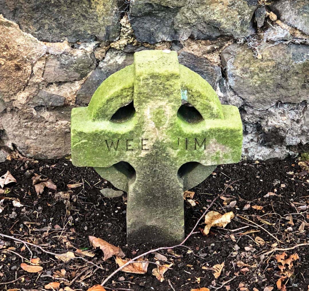 Small celtic  cross grave stone with the words WEE JIM