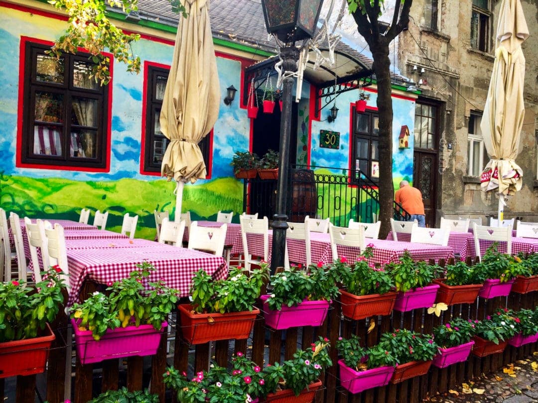 Bohemian-section-Belgrade coloured planter boxes at a ble walled cafe with white and pink seating