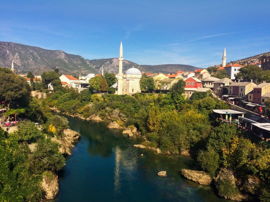 View of river in mostar and distant mosque and tower