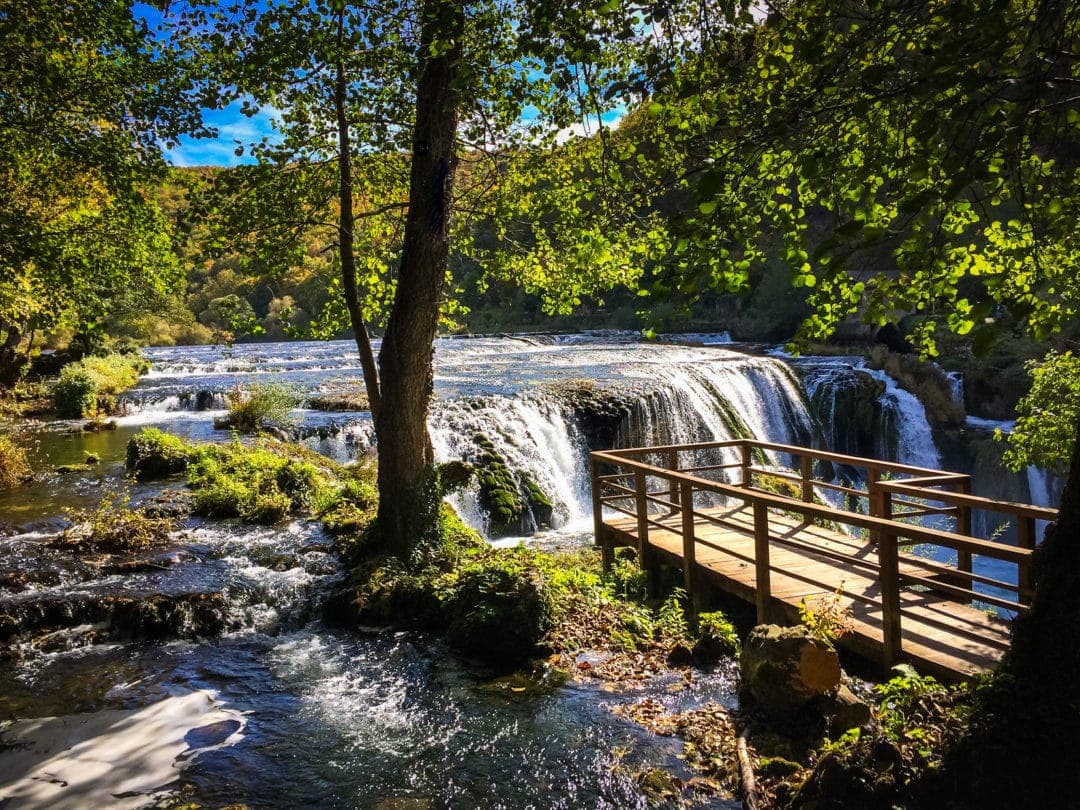 Strbacki-Buk-Waterfall-Bosnia with wooden viewing platform and trees in foreground