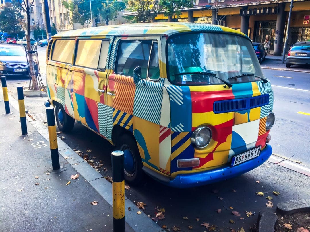 multicoloured VW camper parked on street in Serbia