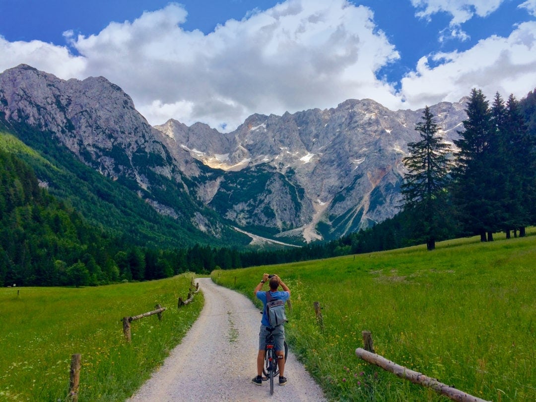 Cycling-in-Zgorne-Jezerco with mountains in the background and green meadows either side of the cycle path